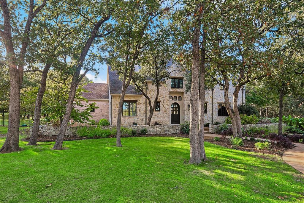 Nestled on 2 serene acres in a quiet cul-de-sac, this stunning English Cotswold-style home combines timeless charm with modern luxury. Zoned to the coveted Argyle ISD and boasting one of the lowest tax rates in the area, this 4-bedroom, 4-bathroom property is a true gem. Inside, you’ll find exquisite finishes, including reclaimed wood floors and accents throughout, lending warmth and character to every room. The thoughtfully designed layout includes a downstairs media room and cozy details that make the home feel inviting and unique. The lush, tree-filled lot features a 1,648 sq. ft. barn, perfect for storage, hobbies, car parking or entertainment. A private well supplies water for the entire exterior irrigation system, ensuring your landscaping stays vibrant year-round. With its picturesque setting and exceptional craftsmanship, this home offers the perfect blend of privacy, sophistication, and functionality. Don't miss this rare opportunity!