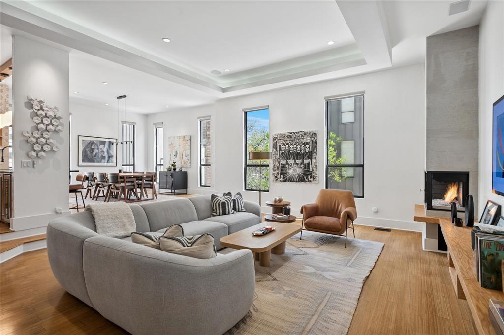 WOW! Front and center views of Reunion Tower and downtown Dallas from expansive 600 sq ft rooftop deck! Experience elevated urban living in this impeccably remodeled modern townhome, ideally positioned between Bishop Arts & Downtown Dallas with rare, unobstructed skyline and Reunion Tower views from rooftop-perfect for sunrise, sunset, al fresco dining, entertaining, & front-row seats to NYE fireworks. Hospital quality UV oxidation light & static air filtration integrated into the HVAC system. A nearly $100K designer renovation (2022) infuses the home with curated style, including refinished bamboo hardwoods across all living levels, updated Sonneman and Schoolhouse lighting, & thoughtful upgrades throughout. The first floor with foyer and a dedicated home office enhanced by dramatic 3D metallic Schumacher wallpaper. The bright & airy main living level features battery-powered shades, built-in surround speakers, abundant natural light, & refreshed fireplace with striking midcentury modern floating mantle. The beautifully updated kitchen showcases oak cabinetry, Manzoni wood-wave hardware, granite countertops, expanded pantry, Samsung Bespoke 4-door fridge, & Schumacher wallpaper accents. Both bedrooms offer ensuite bathrooms. Spacious primary suite includes ceiling speakers & custom closet system, along with a spa-inspired bathroom featuring skylight, quartz countertops, floor-to-ceiling tile spanning the entire vanity wall, pendant lighting, freestanding soaking tub, & large walk-in shower. Third-floor laundry room with custom cabinetry. This prime location offers incredible future value with Harold Simmons Park now under construction—a transformative 250-acre urban nature park along the Trinity River with anticipated access point beside the community. Planned features include scenic trails, playgrounds, nature preserves, waterfront amenities, gathering areas, and innovative outdoor experiences that will significantly enhance the lifestyle and vibrancy of the area.