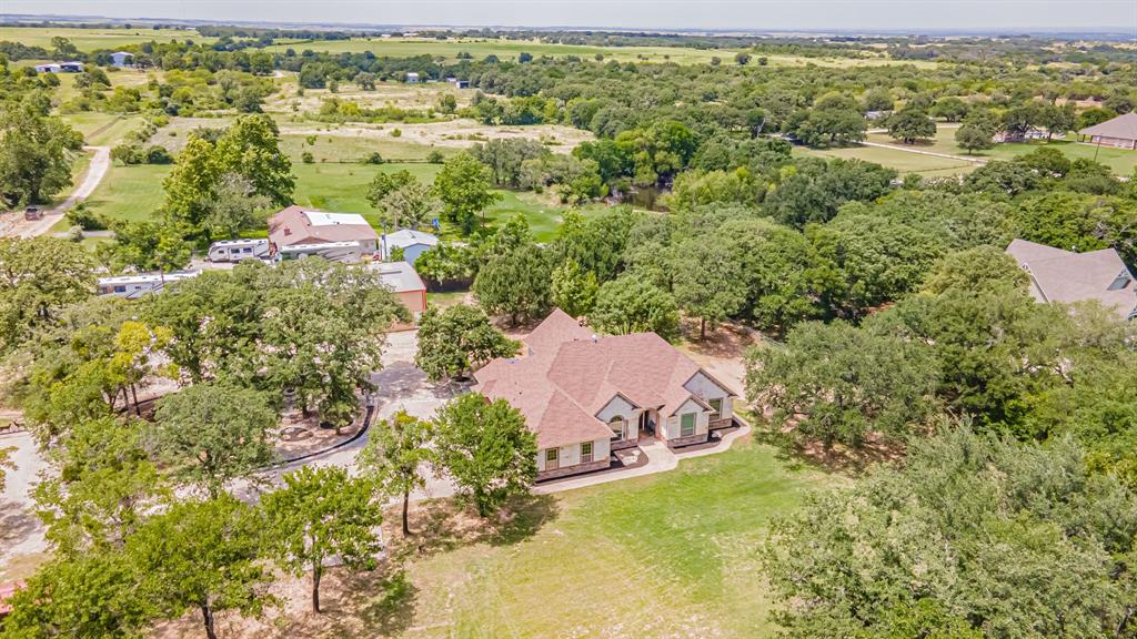 French country style home exuding luxury and elegance!  As you walk in the front door the high-end finishes and details are striking - custom vaulted tray ceilings, arch doorways, quadruple crown, gorgeous, detailed granite, 3 gas log fireplaces and much more. Detailed molding on kitchen cabinets, 6 burner gas cooktop, hearth area, island with custom wood inset, and fireplace. Elegant master bedroom has wood floors, barrel ceiling, sitting area, fireplace. Master bath walk-in shower and 2 separate closets.  Property is on fully fenced acreage. Grandiose shop with double pull through doors and HVAC! Half of the shop converted to airconditioned 19x33 workplace with loft storage above and other half 14x48 RV storage.  Beautiful live oaks for shade and privacy. Great opportunity for home and business in the same location with great visibility. Garage has epoxied floor and ducted HVAC for added living space if needed.  This home is a must see! Sought after Tolar ISD!