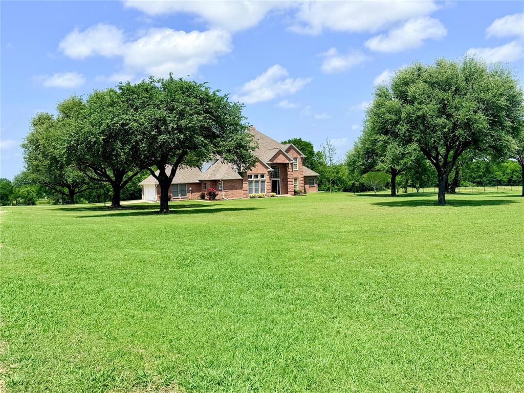 Lifestyle and Legacy, a 26 acre private sanctuary, where comfort meets the great outdoors. Escape the city to this sprawling 25.9 acre estate, designed for those who value privacy without sacrificing comfort. Boasting 3,366 square feet of living space, this 3 bedroom, 3 bathroom home offers ample room for the entire family. The interior is complemented by a two car garage and a versatile workshop-equipment barn, ideal for hobbies or home business needs. The land itself is a natural masterpiece. With over 1,750 feet of road frontage on FM 879, the property is easily accessible yet remains incredibly private thanks to its wooded acreage and the tranquil flow of Village Creek. Nature enthusiasts will love the abundance of local wildlife, while the fenced and cross-fenced pastures make it move-in ready for livestock or horses. Best of all, enjoy the peace and quiet of a county setting with the added benefit of lower property taxes. If you're looking for a place in the country that the whole family can enjoy, then come take a tour today.