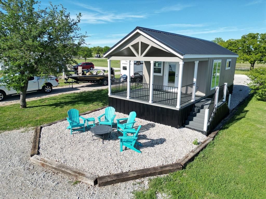 Do you love the lake? How about golf? This new cottage is located along the shores of Lake Leon and immediately adjacent to The Kingdom Course at Solid Rock, providing abundant recreational opportunities. Just an hour east of Abilene and an hour west of Weatherford this would make an easy-to-use getaway that would provide lots of fun times. This Tiny House has a walk in closet, tankless hot water heater, full size appliances, full size shower, farm style sink, quality plumbing fixtures and a huge covered porch! This tiny home may be only 399 square feet but the outside spaces are abundant! Wait until you see the ground level patio area just below the covered porch. From the porch and patio area you will enjoy an amazing sunset view over Lake Leon, making it the perfect place to enjoy a frosty beverage or hang out with friends all summer long. Enjoy spectacular sunsets over the lake after a full day of boating, fishing or playing golf! This is a PERFECT and ECONOMICAL solution for a lock and leave getaway lake house or simplified full time living. Plenty of room to keep your boat on site and still have space for your vehicles on the lot. Short term rental of the unit is allowed by the buyer. Annual lease for the lot is required ($650 per month) and covers water, sewer, basic electric and community mowing and grounds maintenance. Boat ramp, dock, washroom and more is included. Over 2,000 feet of pristine Lake Leon shoreline, tons of wide open green space to enjoy, a fantastic 18-hole golf course right next door AND with all of the shopping and service conveniences of Eastland only 10 minutes away. This is an amazing opportunity to indulge in lakefront living at a price rarely attainable. And the short term rental opportunity gives the opportunity to generate income. The brand new Palo Pinto Mountains State Park is only about 20 minutes away as well! Other models and lots are available within the community at various price points. Reach out for more details!