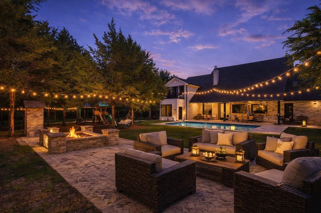 Stop taking vacations and start living in your own private resort! This one-of-a-kind 4,474 SF custom luxury estate sits on 1.74 secluded acres in Waxahachie, TX, offering unmatched privacy, amazing views, and resort-style living. Featuring 6 bedrooms, 3.5 bathrooms, custom details throughout, and a breathtaking backyard oasis with a resort-style pool, this extraordinary property is perfect as a luxury primary residence or a unique short-term rental (Airbnb) investment opportunity. Designed by award-winning interior designer Courtney Warren, this custom masterpiece offers an exceptional blend of elegance, comfort, and modern sophistication. This remarkable estate features multiple living and dining areas and expansive indoor and outdoor living spaces. Step inside to soaring vaulted ceilings with exposed beams and a breathtaking open-concept layout. The main living area flows seamlessly into a stylish dining space and a gourmet kitchen featuring high-end appliances, striking black marble countertops, and designer lighting. The primary suite is a private retreat with beautiful pool views, a double-sided fireplace, and a spa-inspired bathroom designed for ultimate relaxation. LVP flooring run throughout the home, with elegant tile in the bathrooms. Step outside to an outdoor setting that truly sets this property apart - an entertainer’s paradise featuring a sparkling resort-style pool, custom built fire pit, outdoor kitchen, children’s playground, and expansive green space. Whether hosting gatherings or enjoying peaceful evenings under the Texas sky, this property delivers an unparalleled lifestyle. The expansive outdoor setting creates the perfect backdrop for hosting private events, family celebrations, or even intimate wedding gatherings. Experience privacy, design, and resort-style living at its finest. Schedule your private tour today to explore this magnificent estate!