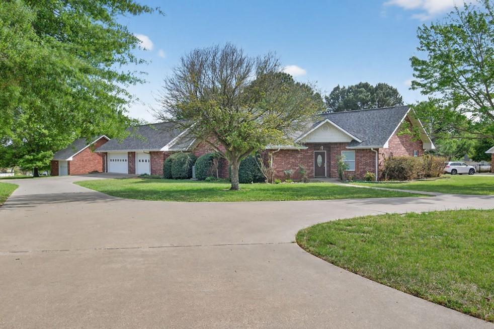 Built in 2004, this 2,024 sq. ft. home offers 3 bedrooms and 3 bathrooms on a full acre just outside the city limits—enjoy no city taxes and a peaceful setting near Lake Athens. Located on a quiet dead-end street, this property provides minimal traffic, scenic lake views, and frequent visits from local wildlife, including deer. Inside, you’ll find an open living and kitchen layout with raised ceilings, granite countertops, a pantry, central vacuum system, and abundant storage throughout. The split-bedroom floorplan offers added privacy, while the spacious primary suite includes a walk-in closet. Recent updates include a brand-new roof (2026) and two tankless water heaters for efficiency and convenience. Step outside to a covered back patio perfect for relaxing and taking in the serene surroundings. The property also features a three-car attached garage plus a detached one-car garage or shop with additional storage. Just a short drive to the marina, this home combines comfort, functionality, and the best of lake area living.
