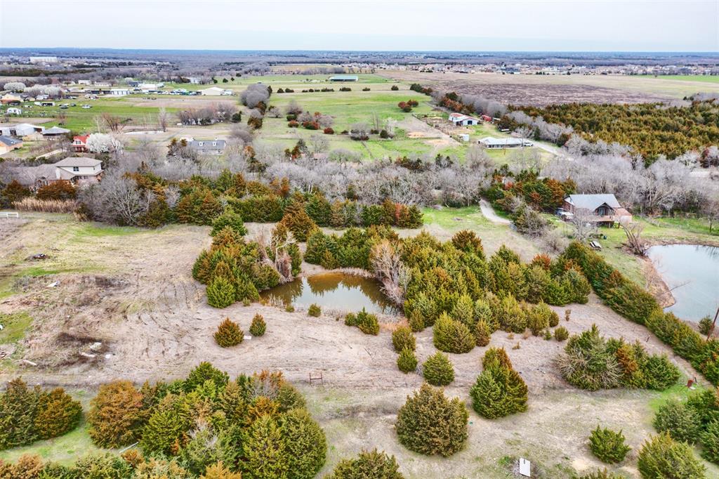 Investor & Lifestyle Opportunity – 3.3 Acres in the Princeton Growth Corridor.  Located within the ETJ of Princeton—one of the fastest-growing areas in North Texas—this 3.3-acre tract offers a unique blend of long-term investment potential and peaceful country living. Tucked off the road with a long private drive, the property provides privacy, quiet surroundings, and a safe, secluded setting ideal for a young family or a relaxed retirement lifestyle.  The property features a 1987-built 3-bedroom, 2-bath home (approx. 1,650 sq ft).  While the home will require some TLC, it offers flexibility for a handyman, investor, or buyer looking to renovate and make it their own.  The land itself is the true highlight—open space with a stock pond suitable for horses or livestock, along with multiple storage buildings and two large carports. A metal roof, less than 10 years old with a lifetime warranty, adds long-term value.  Positioned just minutes from US 380, local schools, retail, dining, and Lake Lavon for fishing and boating, the property offers the feel of small-town living with convenient access to big-city amenities. Surrounded by ongoing residential and commercial growth, this tract presents strong future upside.  Whether you’re looking for a private homestead, a rental hold, or a long-term land investment, this is a rare opportunity to secure acreage in a rapidly expanding corridor. Value is in the land, with added lifestyle appeal.