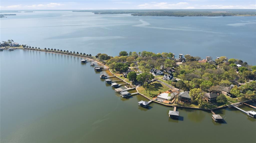 A rare opportunity awaits you in the coveted gated community of Enchanted Isles! This totally updated and remodeled lakefront home features 4 bedrooms and 3 full baths all with breathtaking views and lakeside access from every bedroom and living space. You will especially enjoy your morning coffee in the beautiful morning room off the primary bedroom, which was just completed. The open-concept floor plan, featuring floor-to-ceiling windows and doors facing east toward the lake boasts a gourmet kitchen, with a huge island for cooking and gathering. The family room is especially large to host many friends and family. The outdoor areas include an oversized deck off the family room, a lower-level covered patio, a 5-foot swim spa, and a 2023 boathouse that accommodates a boat and double jet ski lifts. The boathouse is on very deep water because you are on the outermost island. As you enter through the Enchanted Isles gate and drive across the two pine tree-lined causeways, you will know you have found your new ISLAND RETREAT!