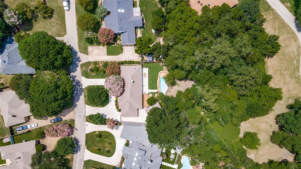 Nestled on a rare half-acre-plus creek lot, this thoughtfully updated North Dallas home offers an exceptional combination of privacy, mature trees, and beautifully designed living spaces in one of the area's most desirable neighborhoods. The backyard feels like a private oasis with a sparkling pool, expansive deck and serene setting surrounded by a lush canopy of trees adjacent to a creek—a combination that is increasingly rare to find.

The well-designed floor plan features five bedrooms, three full bathrooms, multiple spacious living areas, and an open-concept kitchen with a modern aesthetic that flows effortlessly into the living room and overlooks the backyard. Appointed with Monogram appliances, a large center island, vaulted ceilings and thoughtfully curated cabinetry, the kitchen serves as the heart of the home while seamlessly connecting to the main living and entertaining spaces. Expansive windows fill the home with abundant natural light and frame panoramic views of the tree-lined backyard setting.

A standout feature is the detached bonus suite above the garage, complete with a full bath, closet, and kitchenette-style amenities, offering exceptional flexibility as a private guest suite, home office, fitness studio, or space for multigenerational living. A covered patio sits adjacent to an additional separate full pool bath that adds convenience for outdoor entertaining and guests.

Whether relaxing by the pool, enjoying peaceful mornings overlooking the mature trees, or entertaining family and friends, the outdoor setting offers a rare sense of privacy and tranquility. Ideally located in Plano ISD with convenient access to the Dallas North Tollway, George Bush Turnpike, Legacy West, and premier shopping and dining, this is a unique opportunity to own a private creekside retreat on a charming quiet street in the heart of North Dallas.
