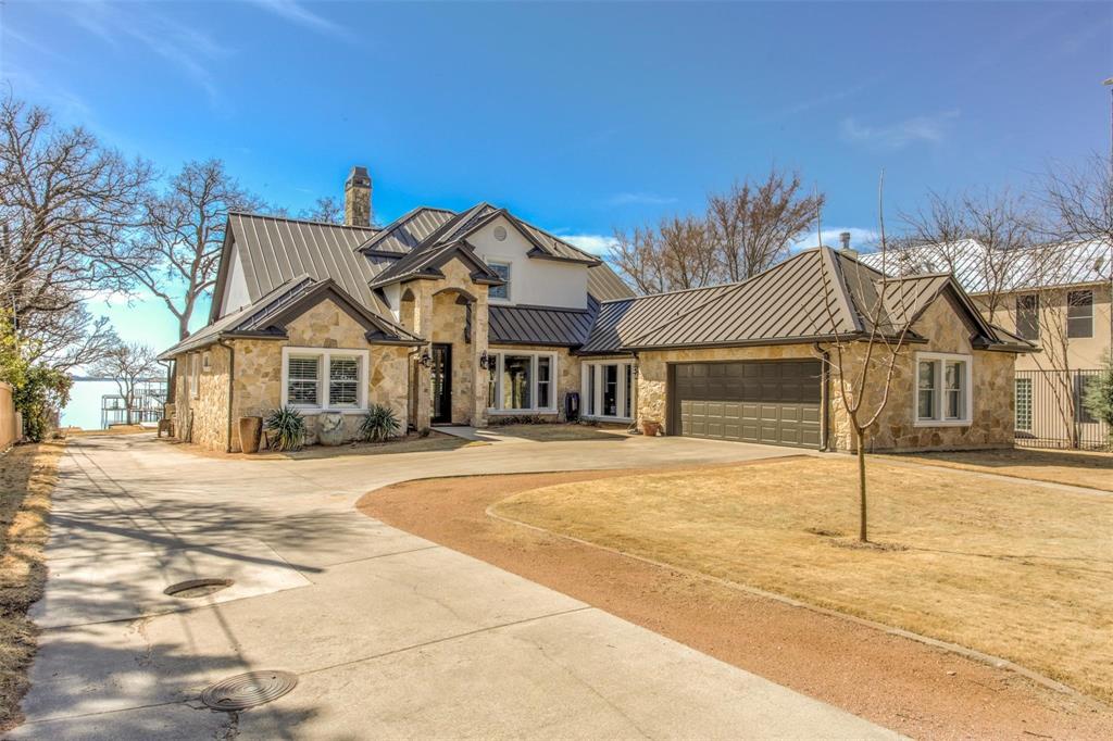 Don't miss this Lakefront home, with acreage on main body of water on Eagle Mountain Lake, in north Fort Worth. From the main street, a quarter mile private road takes you to your own private Oasis! Not only a spectacular main home, this property also has a 1200sf full guest home on premises, 2023 built 2 bedroom 2 bath, kitchen, living and utility. Open floorplan with the most amazing chef's kitchen that has it ALL! HUGE island, built in fridge & freezer, pot filler, double ovens, convection cooktop, warming drawer. An entertainer's dream home, brings the outdoors inside with roll up doors on the climate controlled patio attached. Lifetime memories to be made with sunsets that will take your breath away. 2 story dock with boat slip and jetski lifts. Putting greens out front, sport court, batting cage, and your own private boat ramp! Hand scraped wood flooring., Primary bedroom ensuite on main floor, as well as another bedroom ensuite. Come see today!