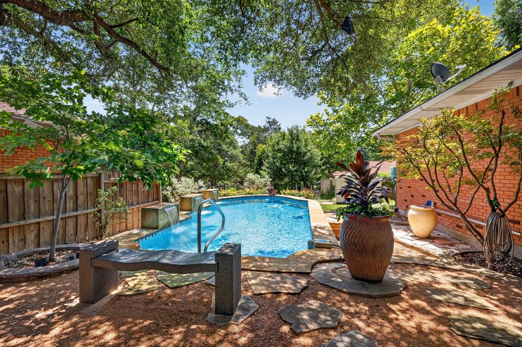 Nestled beneath a canopy of mature trees in one of the area's most desirable neighborhoods, this beautifully appointed residence blends timeless elegance with modern comfort. Designed with an inviting open-concept floor plan, the home showcases rich hardwood flooring throughout the main living areas, tile flooring in the kitchen, a private office, separate laundry room, and an impressive family room centered around a cozy fireplace.

The tranquil primary suite offers a spacious walk-in closet and a spa-inspired en-suite featuring a smart toilet, heated floors, an elegant tiled shower with premium luxury fixtures, while the secondary full bath is enhanced by a beautiful skylight. Mini-split systems in both the primary and secondary bedrooms provide exceptional year-round comfort.

Step into your own resort-style backyard retreat, where a newly re-plastered in-ground pool with a zero-entry design, cascading water features, covered patio, gazebo, slate walkways, and utility shed create the perfect setting for both entertaining and relaxation. Additional highlights include plantation shutters throughout, a brand-new roof, and an oversized carport.

Owner financing is available at 4.75% interest with $200,000 down, with the seller carrying the note—an exceptional financing opportunity rarely available in today's market.