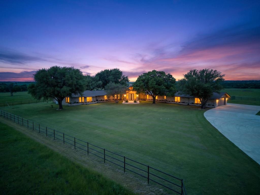 FANTASTIC CUSTOM HORSE PROPERTY! 1-mile (3 min) to Chisolm Trail & 30 minutes to FTW. Gated entrance & security lights. Cross Pipe Fencing. Six theater recliners w-forced air WB fireplace in Den. Brunswick pool table w-Brunswick ping pong topper & shuffle board table. Kitchen has two sinks each w-disposals, Reverse Osmosis filter system, a Meile steamer-convection double oven. Quartzite counters. Pull out cabinets w-plugs. Built-in refrigerator-freezer. Separate ice maker, two trash compactors. Large walk-in pantry & lrg storage drawers under window seating. Oversized laundry room w-2022 refrigerator. Handmade black walnut & oak Bar w-lrg capacity ice maker, wine & bar fridge w-four suede bar stools. Office has handmade cabinetry, large desk and deer skin chair plus a hidden secret door to basement. Full gym complete with equipment set up and gym floor mats. All bedrooms have large closets, shower steam transoms with custom vanities and stone vessel sinks. Master Bedroom is oversized with a wood burning rock fireplace, “His & Her” separate bathrooms & closets. Heated shower floor in “Her” bathroom. All bathrooms have hot-cold bidets. Solid wood interior shutters throughout. All solid wood core doors. All interior doorknobs are black porcelain. Oversized 2-car garage with a concrete side for third car-truck parking. Garage has ice maker, freezer & refrigerator. Roof replaced in 2019. Home has 3,000G water tank, a 500G propane tank + a 22W Generac generator-w-its own 500G propane tank both tanks buried.  150X90 Covered Arena with full kitchen-spectator area, lg TV & bathrm.  75 x 90 Barn has 6 -12 x 12 stalls w-work area, tac room (or apartment) w-bathroom. Arena has 2–30-amp RV outlets Barn has 4-30-amp RV outlets both w-water hook ups.  Custom infrared Sauna. Outdoor Fire Pit comes w-rocking chairs & tables & 6 propane heaters. 40x20 Green House  with evaporative coolers and misting fans-auto irrigated. Yard-32-zone auto sprinkler system. 5-fruit producing orchard.