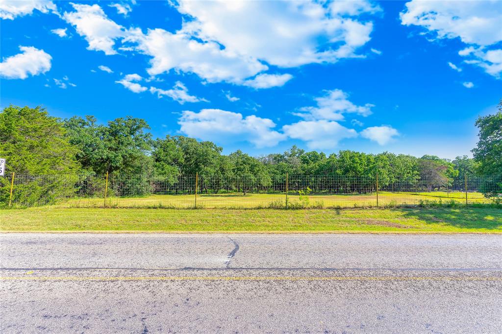 Create your own private sanctuary with this stunning 7 acre property (could be sold as 5 acres with seller retaining back 2 acres).  Perfect for a beautiful homesite or a serene hobby farm.  Nestled in a wooded area with large, mature trees, this land offers a natural animal habitat that ensures peace and tranquility.  Highlights include privacy, secluded, wooded with large trees, natural animal habitat and room for a pond.   Conveniently located between I-35 and Chisholm Trail parkway to the West.  Fully fenced with 8' game fence.  Experience the best of both worlds, tranquility of nature with the convenience of nearby amenities.  Don't miss this rare opportunity to own a slice of nature, see the deer, the peacocks and other woodland animals as you tour the property.  Water and electric access on property.