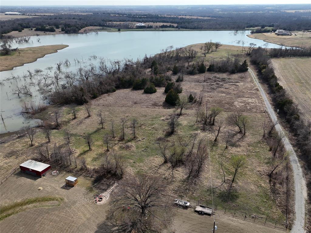 Located in the highly sought-after and rapidly expanding Celina, this exceptional 14.6-acre tract in Collin County offers a rare opportunity to build your dream estate while enjoying the peace and privacy of country living. Situated outside city limits, the property provides flexibility and space rarely found in one of North Texas’ fastest-growing areas.

Tucked back off the road with a beautiful stone entrance and gated access, the property is fully fenced and ready for your vision. Water and electricity are available, making it easier to plan your custom home, barndominium, private retreat, or even a small commercial venture. One of the most breathtaking features is the scenic lake bordering the back of the land, creating incredible views and a tranquil backdrop that is difficult to find in today’s market.

While the property offers privacy and open space, it is also positioned in the path of tremendous growth. Celina has been recognized as one of the fastest-growing cities in the United States, with significant new commercial and infrastructure development underway.

Major projects nearby include the $1-billion Shawnee Trail mixed-use development, bringing retail, restaurants, entertainment, and residential communities anchored by a new Walmart Supercenter. Additionally, the massive Legacy Hills development along the future Dallas North Tollway extension will feature major retail destinations including a future H-E-B grocery store and the city’s first championship golf course. New businesses, retail centers, and industrial developments continue to move into the area as Celina’s population and economy rapidly expand.