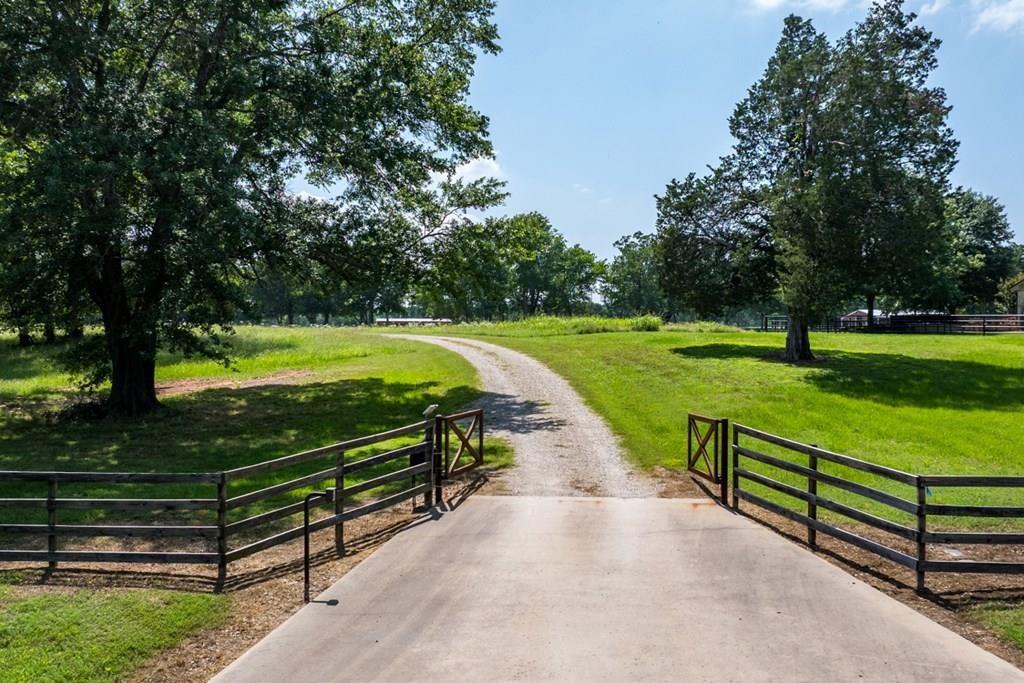 Nestled in the picturesque Van Zandt County, this agriculturally exempt property spans over 69 scenic acres, offering the tranquility of rural living with convenient access to Dallas, Tyler, and Mabank for all your shopping and entertainment needs. This secluded residence is set off a winding road, providing a beautiful journey to the house while ensuring privacy and seclusion. Surrounded by towering Texas timber, the property boasts a stunning backdrop with varying elevations and abundant character. The residence offers an inviting 1,800+- square feet of finished space, featuring a cozy, charming three bedroom, two bathroom barndominium, and an attached garage or workshop with over 1,400+- square feet of ample storage. This additional space is perfect for hosting large gatherings or events, making it ideal for entertaining. Should you require a larger home, the attached shop can be finished for additional living space. The garage or workshop is equipped with three large roll-up doors, perfect for storing farm equipment. or adding on to the home size. The home features a well-designed open floor plan, ensuring a seamless transition from the living room to the kitchen. The kitchen is outfitted with granite countertops, stainless steel appliances, a gas stovetop, and tankless water heaters. Spend your evenings gazing at the stars over the charming country landscape from the covered patio with amazing views. Additionally, there is a 30x40 shop on the property with an overhead door, offering even more storage space. of could be finished out for a second home, guest house or bunk house. A creek meanders through the property, attracting an abundance of wildlife, making it an excellent location for hunting or wildlife observation. There is a great opportunity to create ATV or walking trails among the trees, with a pond on the property.