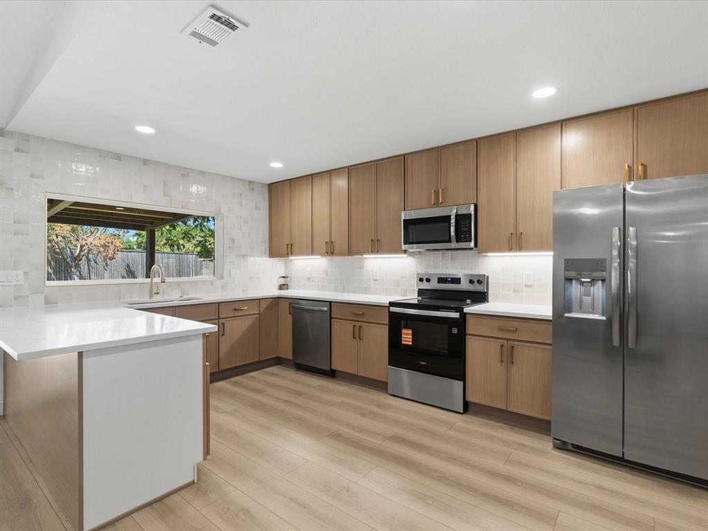 Welcome to 2039 Chestnut Rd, a beautifully reimagined home tucked into the established Woodlake neighborhood of Carrollton. Sitting on a generous 0.30-acre lot with mature trees and a sprawling privacy-fenced backyard, this 1,856 square foot brick ranch blends classic bones with a complete top-to-bottom modern refresh. 

Step inside to discover a wide-open floor plan flooded with natural light from the home's signature arched front window. The chef-inspired kitchen is the showstopper, featuring light oak shaker cabinetry with brass hardware, gleaming quartz waterfall countertops, designer subway tile backsplash, under-cabinet lighting, brand-new stainless steel appliances, and a center island built for entertaining. Luxury vinyl plank flooring flows seamlessly through the great room, where a striking oversized ceiling fan crowns the soaring vaulted ceiling.
The primary suite offers a walk-in closet and ample natural light, while two additional bedrooms provide flexible space for family, guests, or a home office. Out back, enjoy a covered patio overlooking one of the largest yards on the block, perfect for weekend gatherings, a future pool, or a pets dream playground. The garage is a standout in its own right, finished with sleek epoxy flooring and statement hexagon LED lighting, ready for the car enthusiast, home gym, or workshop of your dreams.
Walking distance to Furneaux Elementary, neighborhood greenbelts, and a community pond. Zoned to Furneaux Elementary, Long Middle, and Creekview High in Carrollton-Farmers Branch ISD. Quick access to I-35E, the President George Bush Turnpike, and DFW Airport. Move-in ready and turn-key, this is the one you have been waiting for.