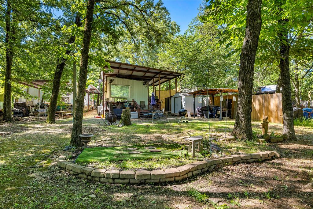 Welcome to waterfront living in the gated community of Sun Eagle Bay on world famous Lake Fork! This unique lakeside retreat features a site built structure built around an RV, offering the perfect blend of comfort, functionality, and relaxing lake life. The RV includes the kitchen, dinette, full bathroom, and sleeping area, while the thoughtfully designed addition features an inviting entry hallway, spacious living room, stackable washer and dryer space, private primary bedroom with a stunning picture window overlooking the lake, and an additional full bathroom. Step outside and enjoy mature shade trees, expansive covered decking ideal for entertaining or unwinding with lake views, plus your own fishing pier perfect for casting a line or tying up your boat after a day on the water. Sun Eagle Bay offers fantastic amenities including gated access, community boat ramps, fishing pier, swimming pool, playground, and volunteer fire department. Whether you are looking for a weekend getaway, full time residence, or fishing retreat, this waterfront property delivers the laid-back Lake Fork lifestyle buyers are searching for!