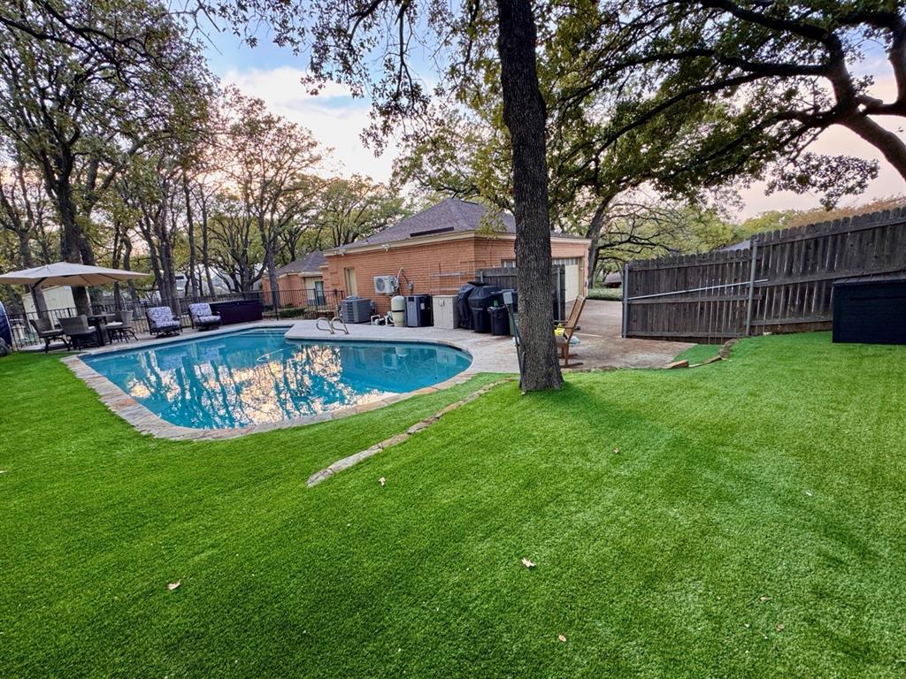 Fantastic property with a pool and 3-car garage located on a beautiful wooded corner lot of a small cul-de-sac.  Recent updates and standout features include a premium pebble-finish resurfaced pool, polyaspartic garage floor coating and a mini-split AC in the 3-car garage - making it a great space for a home gym or workshop.  The backyard also features low-maintenance turf around the pool, a newer standalone hot tub, and mature oak trees that provide excellent summer shade.  Additional upgrades include luxury vinyl plank flooring in two bedrooms and Ring security coverage with a doorbell camera plus three floodlight cameras at key entrances.  Extra large living area with stone fireplace, formal dining area, great game room with wet bar and refrigerator, and spacious kitchen and breakfast area are perfect for family and entertaining.  The floor plan has a three-way split of four spacious bedrooms and three baths plus a half bath off pool and garage.  Plantation shutters throughout the house, ceiling fans, vaulted ceilings, abundance of storage space, nice landscaping and sprinkler system.  The sun room allows for bonus room or added living space.  Iron fence in pool area to separate it for safely.  Extra parking space on wide driveway for 3-car side-entry garage.