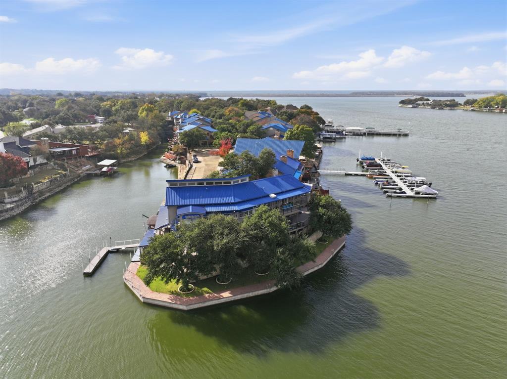 Do not miss out on this extraordinary waterfront property on an Eagle Mountain Lake peninsula with 239 ft of shore front! This home is beautiful and has views for days. This one-of-a-kind lakefront home is in the exclusive gated community of Bal Harbour on Eagle Mountain Lake. This custom-designed showplace offers approximately 4,700 sq ft of beautiful modern living space, combining luxurious finishes, unforgettable entertainment features, and panoramic lake views. This 4-bedroom, 3.5-bedroom, 3 car garage home has everything you need and is perfect for multi-generational families or those that receive a lot of guests. Recent renovations inside include a state-of-the-art kitchen, updated designer lighting, all new primary bath, flooring & paint throughout, downstairs shower, windows & sliders, gorgeous focal point gas fireplace and new entry way glass door. Outside renovations include all new decking and balconies, a beautiful water fountain, full landscaping and an extensive outdoor lighting system that is sure to impress. This home has two boat slips, one private slip next to the house and one steps away at the private marina located just beyond the community pool. Whether entertaining, relaxing, or enjoying life on the water, this rare lakefront gem offers the best of Eagle Mountain Lake living. Property is listed at $200,000 under recent appraisal and a pre-sale inspection has been done.
