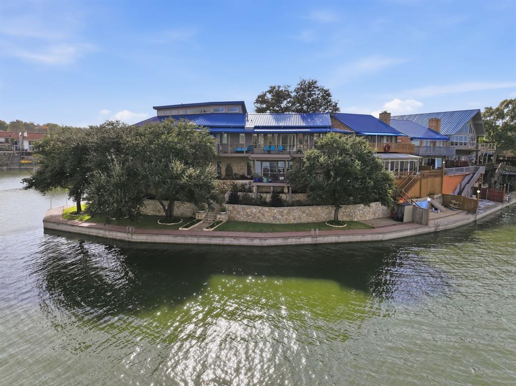 Do not miss out on this extraordinary waterfront property on an Eagle Mountain Lake peninsula with 239 ft of shore front! This home is beautiful and has views for days. This one-of-a-kind lakefront home is in the exclusive gated community of Bal Harbour on Eagle Mountain Lake. This custom-designed showplace offers approximately 4,700 sq ft of beautiful modern living space, combining luxurious finishes, unforgettable entertainment features, and panoramic lake views. This 4-bedroom, 3.5-bedroom, 3 car garage home has everything you need and is perfect for multi-generational families or those that receive a lot of guests. Recent renovations inside include a state-of-the-art kitchen, updated designer lighting, all new primary bath, flooring & paint throughout, downstairs shower, windows & sliders, gorgeous focal point gas fireplace and new entry way glass door. Outside renovations include all new decking and balconies, a beautiful water fountain, full landscaping and an extensive outdoor lighting system that is sure to impress. This home has two boat slips, one private slip next to the house and one steps away at the private marina located just beyond the community pool. Whether entertaining, relaxing, or enjoying life on the water, this rare lakefront gem offers the best of Eagle Mountain Lake living. Property is listed at $200,000 under recent appraisal and a pre-sale inspection has been done.