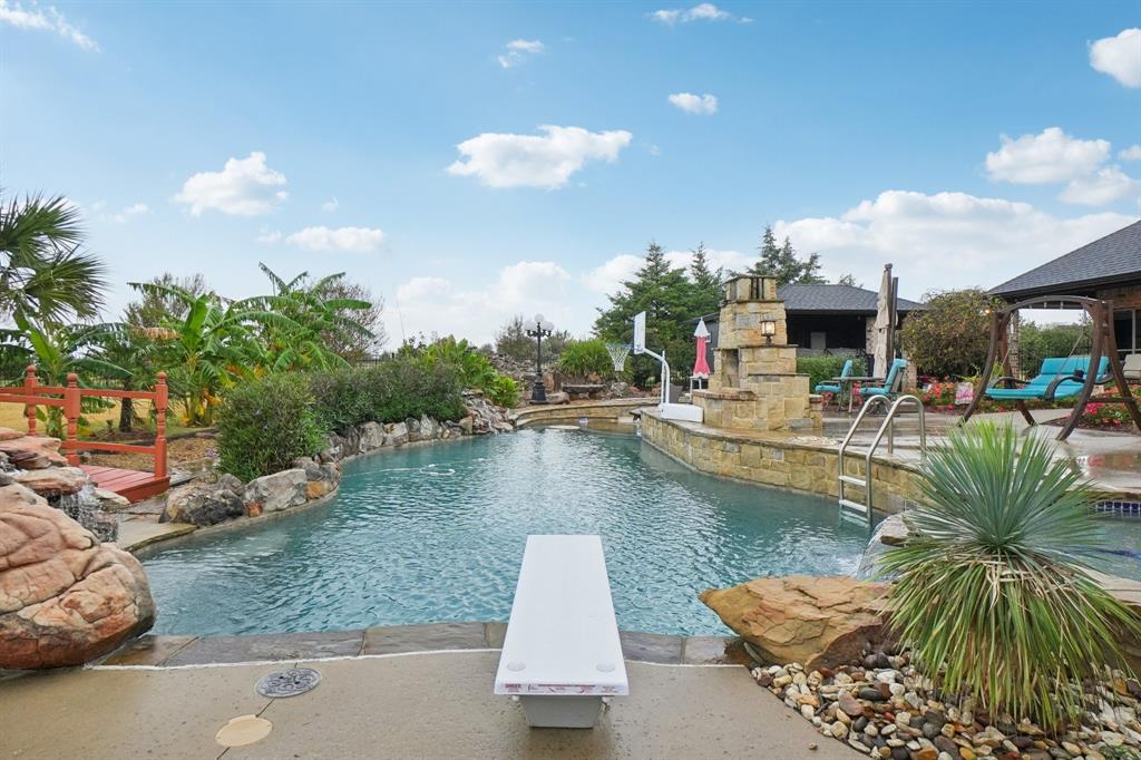 Discover this extraordinary retreat where luxury living meets resort style living in the heart of Rockwall! This stunning property boasts one of the most impressive backyard living spaces designed to entertain, unwind and inspire year round. Challenge your skills on the custom putting green or take a dip in the pool with two water features while watching the stream cascade from the giant waterfall into the private fishing pond. Then check out the covered hot tub & swim spa at the Pool Cabana. The pool cabana has its own shower, bathroom & sink & its also air conditioned & heated! The outdoor grill & fridge under the covered patio rounds off the perfect outdoor experience. The interior of the home is equally amazing. The inviting entry way leads to a large dining area, flanked by an oversized office or formal living room. Take a stroll into the spacious gourmet kitchen featuring granite counter tops, double ovens, reverse osmosis system at the kitchen sink, breakfast area & bar area with extra lighting overlooking the living room. The living room features a stone fireplace with built ins on each side for extra design & storage. The primary bedroom is private & seperate from the other bedrooms & has a fantastic view of the serenity of the backyard. The primary ensuite bathroom features a large, negative edge walk in shower, soaking & jetted tub, separate His & Her sinks, linen closet and huge walk in closet. On the opposite end of the hallway you will find the utility room with a folding table, sink & room for a secondary fridge across from the half bath. Next is a guest bedroom with its own ensuite bathroom & two bedrooms that share a jack-n-jill bath. At the end of the hall is the upstairs media room. Just off the media room is a decked attic with lots of storage. The 3 car garage is located just a few steps away from the hallway & media room. All of this is located on 1.7 acres along with beautiful exterior & NO HOA! This is more than a home, its a DESTINATION!