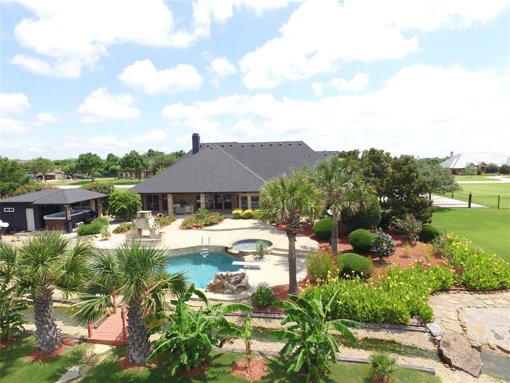 Discover this extraordinary retreat where luxury living meets resort style living in the heart of Rockwall! This stunning property boasts one of the most impressive backyard living spaces designed to entertain, unwind and inspire year round. Challenge your skills on the custom putting green or take a dip in the pool with two water features while watching the stream cascade from the giant waterfall into the private fishing pond. Then check out the covered hot tub & swim spa at the Pool Cabana. The pool cabana has its own shower, bathroom & sink & its also air conditioned & heated! The outdoor grill & fridge under the covered patio rounds off the perfect outdoor experience. The interior of the home is equally amazing. The inviting entry way leads to a large dining area, flanked by an oversized office or formal living room. Take a stroll into the spacious gourmet kitchen featuring granite counter tops, double ovens, reverse osmosis system at the kitchen sink, breakfast area & bar area with extra lighting overlooking the living room. The living room features a stone fireplace with built ins on each side for extra design & storage. The primary bedroom is private & seperate from the other bedrooms & has a fantastic view of the serenity of the backyard. The primary ensuite bathroom features a large, negative edge walk in shower, soaking & jetted tub, separate His & Her sinks, linen closet and huge walk in closet. On the opposite end of the hallway you will find the utility room with a folding table, sink & room for a secondary fridge across from the half bath. Next is a guest bedroom with its own ensuite bathroom & two bedrooms that share a jack-n-jill bath. At the end of the hall is the upstairs media room. Just off the media room is a decked attic with lots of storage. The 3 car garage is located just a few steps away from the hallway & media room. All of this is located on 1.7 acres along with beautiful exterior & NO HOA! This is more than a home, its a DESTINATION!