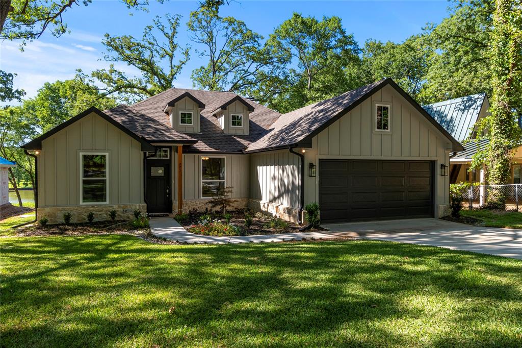 Gorgeous lake front home with sprawling back yard spread located on a quiet cove! The home features 3 bed +office and 2 baths. Fantastic open layout with large kitchen with oversized island, SS appliances, and quartz counter tops. Living room with beautiful wood-burning stone fireplace and hearth, sliding glass doors overlooking the backyard and lake. Decorative shiplap wall in dining area. Primary bedroom with sliding glass doors out to back patio and large walk-in closet. Spacious primary bath with separate shower, soaking tub, quartz counters, and dual sinks. Secondary bedrooms with ample closet space. Guest bathroom features combo tub & shower, single vanity with quartz counter. Luxury vinyl plank flooring throughout and carpet in bedrooms. Backyard paradise with 2-story dock, boat slip and lift, cedar arbor and fire pit, hot tub included. Home is currently an Airbnb. Furnishings and appliances are negotiable.