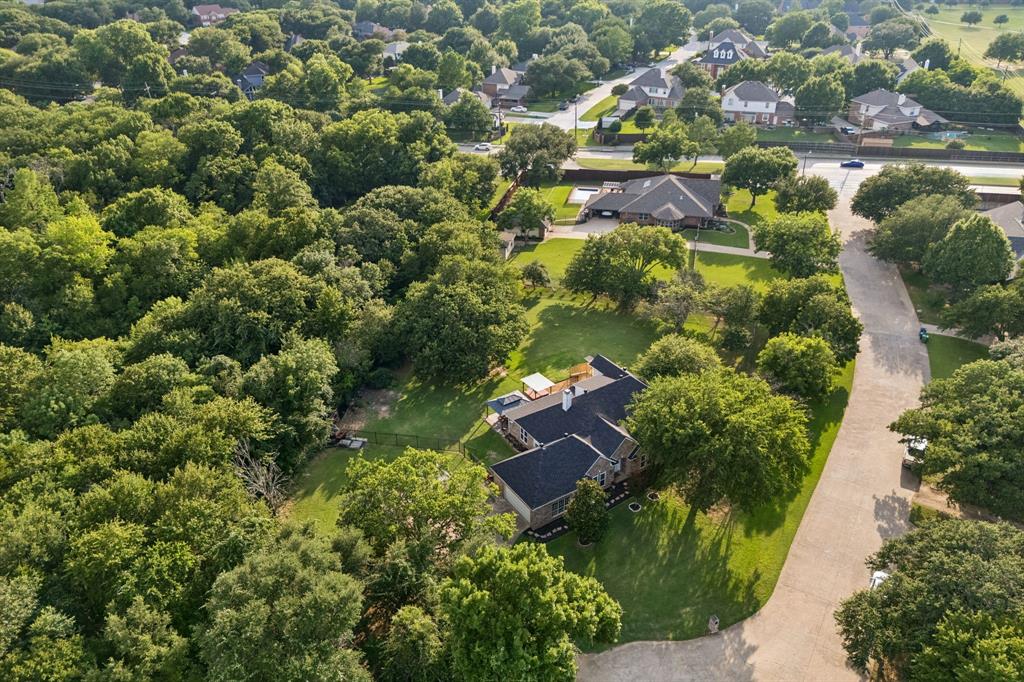 Welcome to holly lane where you will find a rare nearly 1 acre lot in the heart of DFW. Recently renovated and tucked away on a quiet and private cul de sac, 1092 Holly Lane in Lewisville offers a timeless blend of character, space, and outdoor living in a beautifully treed setting. This home spans 3,021 square feet and welcomes you with wood look tile flooring and a spacious living room centered around a cozy fireplace with a beautiful beamed ceiling, flowing seamlessly into the dining area and a well appointed kitchen featuring granite countertops, an induction cooktop, and a bright breakfast area with direct access to the backyard. The primary suite boasts a fully redesigned ensuite bath with a double shower featuring rain showerheads, dual vanities, and separate his and hers water closets two secondary bedrooms and a full bath complete the main level.

A circular staircase leads upstairs to a versatile game room, exercise room and office area with access to a walk out balcony, adding even more functional space. Step outside to experience a backyard designed for entertaining and relaxation, featuring a pergola, hot tub, and plenty of room to gather under mature trees. Additional highlights include a workshop with electrical power, RV parking with hookups, and ample space for hobbies or storage. Located in the heart of Lewisville, this home offers convenient access to major highways, shopping, dining, and entertainment, as well as nearby parks and Lewisville Lake for outdoor recreation. This property combines comfort, charm, and lifestyle in a prime location.