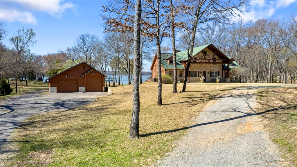 Welcome to an exceptional Lake Fork waterfront estate located at 788 RS County Road 3500 in Emory, Texas, nestled within the highly desirable Northshores community on the west side of Lake Fork. This established waterfront neighborhood is known for its natural beauty, abundant wildlife—including deer, raccoons, and armadillos—and convenient access from the DFW Metroplex. This impressive 4,108 square foot custom home offers 4 bedrooms and 3.5 bathrooms, blending rustic charm with grand architectural design. Inside, you’ll find a striking hand-carved log staircase, a massive great room with cathedral ceilings, a wood-burning fireplace, and expansive picture windows that frame breathtaking lake views and fill the home with natural light. Outdoor living is unmatched, featuring a spacious entertainment area complete with an outdoor kitchen and fireplace—perfect for hosting family and friends year-round. Waterfront amenities include a two-slip boathouse, private boat ramp, and concrete retaining wall, providing effortless lake access for boating and fishing enthusiasts. Adding even more value is a detached two-car garage with a new 815 square foot living addition. This versatile space is ideal for guest quarters or entertaining and includes a mini kitchen, full bathroom, pool table area, and an upstairs bedroom. Located just minutes from Emory, this rare Lake Fork property combines luxury, privacy, and convenience—making it an ideal full-time residence, weekend retreat, or investment opportunity on one of Texas’ premier fishing lakes.