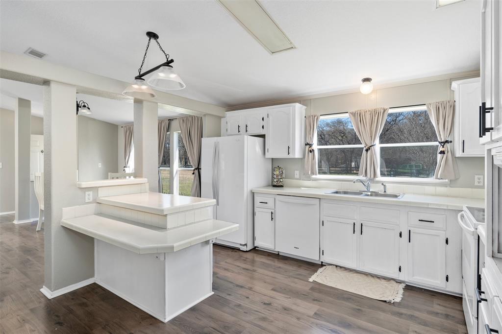 Tucked away on over 13 beautiful acres in Whitney, Texas, this fully updated 3 bedroom, 2 bathroom modular home offers 1,680 square feet of comfortable living space surrounded by peaceful country scenery. Renovated in 2022, the home features modern finishes, an open concept layout, and spacious living and dining areas designed for both everyday living and entertaining. Large windows provide abundant natural light and showcase scenic views of the property’s mix of open grazing land and mature wooded areas. The outdoor improvements completed in 2024 transform this property into a true private retreat. Enjoy your fishing pond filled complete with a new deck and floating dock perfect for relaxing, fishing, or entertaining. The property also features new front and back fencing, offering both security and functionality for livestock, pets, or privacy. Additional improvements include a storage shed and two shipping containers connected by a covered parking area. One container has been thoughtfully converted into a dedicated exercise room, while the other provides excellent equipment and tool storage, offering flexibility for hobbies, fitness, or workspace needs. With a blend of open pasture and wooded acreage, this property provides endless opportunities for recreation, gardening, livestock, or simply enjoying the quiet Texas countryside. Located in Whitney, Texas near Lake Whitney and within convenient driving distance of the Dallas Fort Worth area, this property is ideal as a full time residence, weekend getaway, or private retreat. Rare opportunity to own versatile acreage with move in ready improvements, scenic views, and exceptional outdoor amenities.