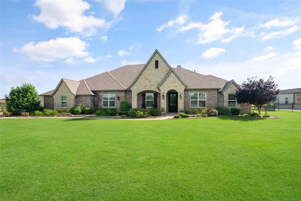 Welcome to 588 Horseshoe Bend, a stunning custom home situated on 2 beautifully maintained acres in the sought-after High Point Ranch community of Royse City. Thoughtfully designed with quality craftsmanship and exceptional upgrades throughout, this 4-bedroom, 3.5-bath home offers the perfect blend of luxury, comfort, and functionality. Step inside to discover hand-scraped hardwood floors, soaring 10-foot ceilings, a dramatic 12-foot ceiling in the family room, custom wood beams, shiplap accents, pocket and barn doors, and solid 8-foot wood interior doors. The spacious study and versatile game room provide flexibility for work and play. The chef's kitchen is truly the heart of the home, featuring dual islands, an apron-front sink, prep sink, commercial-grade refrigerator-freezer, 8-burner double oven propane range, walk-in pantry reinforced as a storm room, soft-close cabinetry, and a whisper-quiet cabinet-front dishwasher. The family room boasts a cozy wood-burning fireplace and wiring for surround sound. The luxurious primary suite offers dual walk-in closets with a built-in dresser, spa-like bath with soft-close drawers, and thoughtful custom features throughout. Additional highlights include a tankless water heater, dual-zone HVAC, fixed attic stairs leading to full standing-room storage, and high-speed fiber internet availability. Enjoy country living at its finest with a fully fenced 2-acre lot, zoned irrigation system, covered outdoor kitchen complete with grill, sink, and bar area, and an expansive backyard with ample space for a pool, pavilion, firepit, and more. A 20x30 workshop with insulated door, electricity and a 30-amp connection, storage, or business needs. Additional features include a home security system, solar screens, upgraded underground aerobic septic system, and outlets under the eaves for holiday lighting. This exceptional property combines luxury finishes, modern conveniences, and wide-open spaces to create the perfect place to call home.