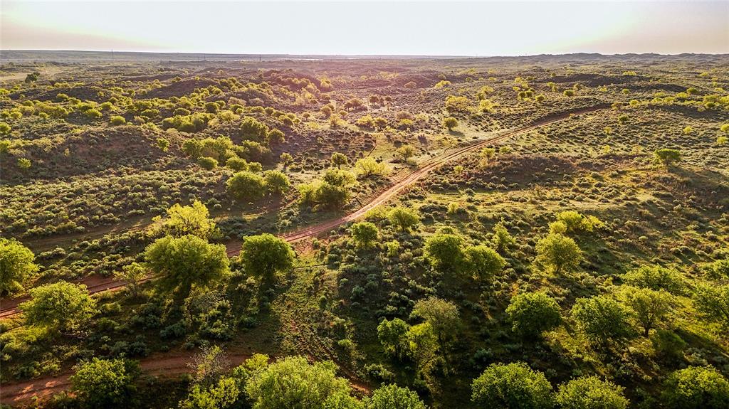 The Sandhill Ranch, located outside of Estelline, TX, covers 6,895 acres and features 4.5 miles of river frontage along the Prairie Dog Town Fork of the Red River. This place is truly a sportsman's paradise offering some of the best free range hunting for trophy mule deer, whitetail, quail, turkey, dove, and hogs. The terrain is perfect for horseback riding and off roading, and it comes with a lodge that sleeps 29 people, plus a 3 bedroom, 2 bath foreman's house. The terrain shifts dramatically across the property. You’ll find some open sand dunes on the northwest side of the ranch near the river, but most of the ranch you will find hills that are covered in native grasses and good forage, ideal for both wildlife and cattle. The river flats and riverbed add another level of diversity that really makes this ranch stand out. The ranch is set up to handle major cattle, farming, and commercial hunting operations without missing a beat. Located 200 miles from the DFW Metroplex and 100 miles from Amarillo. 20 minutes away is the Childress Municipal Airport with a 5,949 ft runway. Sitting on top of the Seymour Aquifer, the ranch has 17 working water wells plus numerous surface tanks. The fencing is in great shape 19 miles of perimeter fence and over 16 miles of cross fencing. There's also a 2.5 mile cattle alley running from the headquarters to working pens in the bottom pasture.  The foreman’s or guest house has been recently remodeled and includes 3 bedrooms, 2 baths, and 2 living areas. A 7,600 SF workshop and barn comes with an office, 2 full bathrooms, tons of corrals and working pens, and a hydraulic chute. There’s even a dedicated dog kennel area with 9 covered runs, all plumbed with water. Additional outbuildings include an 8,000 SF hay barn and a 1,800 SF equipment shed. The ranch is loaded with strategically placed hunting blinds, corn and protein deer feeders, quail feeders, and turkey feeders to support incredible hunting year-round.