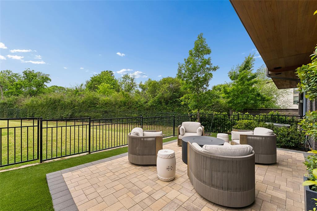 The ultimate lock and leave luxury lifestyle. Positioned in the absolute premier location within The Reserve, this rare 2,700 sq ft designer owned residence is significantly larger and more upgraded than the community’s standard 2,100 sq ft builder grade units. Tucked quietly at the back of the complex, your private back gate opens directly onto a private 1 acre resident park, which connects seamlessly to the Bachman walking trail, giving you peaceful, expansive green views without the maintenance. Built in 2021 and purchased in 2022, the home was transformed by its professional designer owner with high end custom finishes. The spacious interior features custom built oak cabinetry in the living room, designer lighting, and a bespoke dining room bar with an integrated wine fridge and professional grade wallpaper. The upstairs loft serves as a perfect home office, complete with a custom built in desk and matching cabinetry. Every detail has been elevated, including stylish wallcoverings in the powder and primary baths.
Step outside to a low maintenance private oasis featuring a professional paver patio, premium artificial turf, and a gourmet outdoor kitchen equipped with a modular 6 burner grill and searing station. The garage is equally organized with epoxy flooring, custom cabinets, and heavy duty ceiling racks.
Centrally located with a straight shot to Love Field, DFW Airport, and all major highways, this is a secure, luxurious sanctuary built for those who love to travel but refuse to compromise on space, privacy, and high end design. Once you step inside and see the park view, you will see why this stands far above the rest.