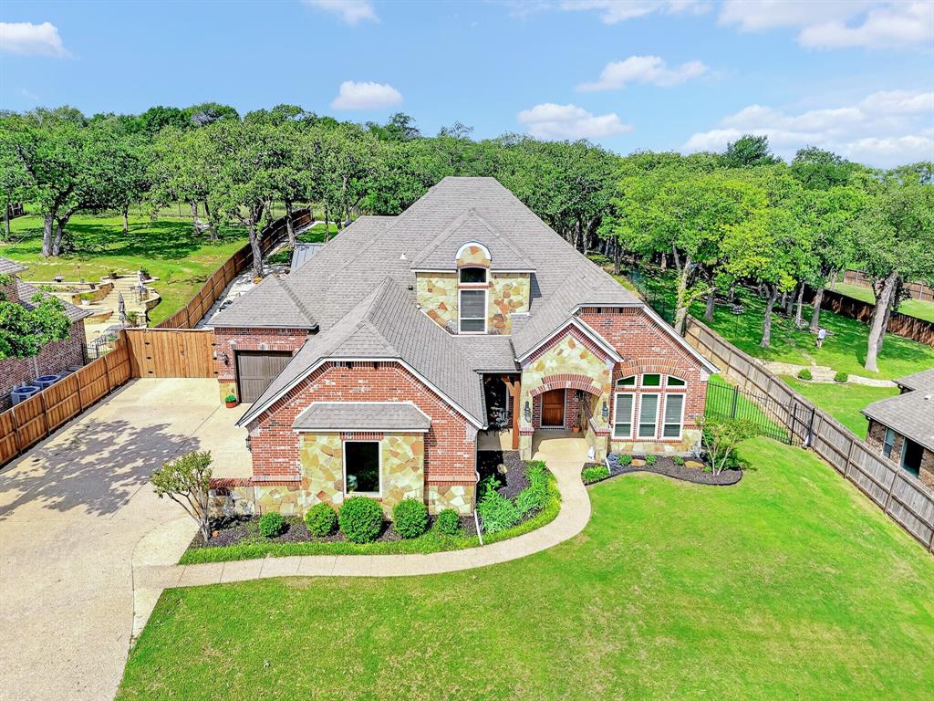 Gorgeous 4-bed, 3.5-bath home with study and game room on a half-acre lot in the gated Eagle Mountain Lake golf course community. Bright, open layout with large windows overlooking a private, wooded greenbelt meaning no rear neighbors! Kitchen boasts an abundance of counter top space with granite countertops, induction cook top, stainless-steel appliances, water filtration system and under cabinet lighting. Spacious primary suite with dual vanities, jetted tub, separate shower, and large walk-in closet. Updated backyard is an entertainer’s dream with a stunning A-frame fully equipped outdoor kitchen with Coyote grills, ice maker, residential refrigerator, and large island with gas fire feature. You’ll also enjoy a new pool with an oversized spa and enjoy relaxing in front of a stunning stone fireplace. Recent updates include all new energy efficient windows, wood tile downstairs, new AC unit, epoxy flooring in both garages featuring 3 parking spots, 8 ft fence with extended driveway to park your boat or jet skis to save on storage fees, new Generac generator, and top of the line turf. The boat ramp, golf course, and clubhouse are all within walking distance. If this backyard oasis isn’t enough, you can still enjoy the Resort community including a championship golf course, 2 pools, fitness center, lake access, tennis and basketball courts, and clubhouse – where the show Landman was filmed!