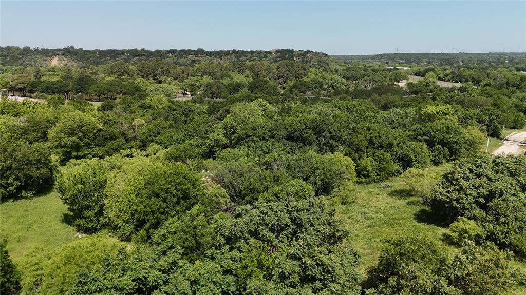 Graham, Texas City Limits 2.77 acres. Zone Mixed Use on Commercial Corridor  
2.77 acres with new survey located between 5th Street and 6th Street at Grove in Graham, Texas; look for new survey flags. The south boundary runs along 5th Street and Grove, and the north side extends to 6th Street at the end of Grove, providing strong layout potential for future development.

There is currently no established access point; however, the south side offers the opportunity for entrance development off State Highway 67 (buyer to verify with TxDOT and city). Positioned within a designated Commercial Corridor and zoned mixed-use, this tract presents excellent potential for a truck yard, equipment yard, contractor facility, storage development, or other commercial applications.

The property is primarily brush with mature trees and native vegetation throughout — a true blank slate ready for clearing, cleanup and improvement to fit your vision. This property is adjacent to protected city-owned green space along Salt Creek and backed by long-term recreational land preservation. 

Bring your plans and explore the possibilities this location offers.