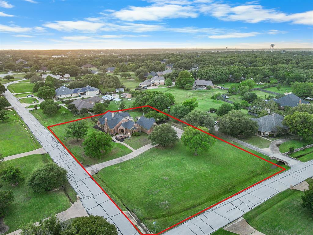 Rarely does a property offer this combination of space, flexibility, and location. Situated on a prominent corner lot spanning more than an acre in highly sought-after Double Oak, this beautifully updated home offers four bedrooms on the main level, no HOA, and highly rated Flower Mound schools. Designed to live like a single-story, the thoughtful floor plan provides exceptional convenience for everyday living, multigenerational households, or long-term flexibility. Upstairs, a private bedroom, full bath, and bonus living area create the perfect retreat for guests, hobbies, or homeschool. Lovingly maintained and thoughtfully updated over the years, this home reflects true pride in ownership with extensive improvements to both its systems and finishes. Beyond its flexible floor plan and exceptional lot, the property stands out for its long list of meaningful updates and careful maintenance, allowing the next owner to enjoy the home rather than immediately tackling major projects. Inside, the living room, parlor, and dining areas flow seamlessly together and are highlighted by lead-glass windows that fill the home with natural light. A wooden spiral staircase serves as an architectural focal point, while the renovated kitchen features quartz countertops, custom cabinetry, under-cabinet lighting, updated appliances, and soft-close drawers. The acre-plus backyard offers new wrought iron fencing, a pool and spa, mature trees, and expansive lawn space for entertaining, recreation, or quiet enjoyment. Major improvements include a Class 4 impact-resistant roof, updated HVAC systems, renovated bathrooms, updated flooring, fresh paint, lighting enhancements, and additional upgrades throughout. Conveniently located near restaurants, retail, golf, and DFW airport, this property is a must-see!