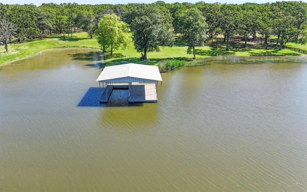 Beautiful waterfront home on Lake Tawakoni! A property like this is hard to find sitting on 2.5 acres with an additional 1.5 SRA acreage, over 440 feet of lake frontage, huge, scattered oak trees, over 3100 sq feet of deck space overlooking the lake. This home offers almost 1900 sq feet 3 bd 2 bathrooms, panoramic lake views from the open concept kitchen, dining and large living room and oversized primary bedroom. The entire house was completely updated in 2024, new roof, beautiful hardwood flooring throughout, marble countertops, fresh paint, new bathrooms, and so much more. There is a large, covered boat dock with a boat slip, fish cleaning station, all new wiring ran to the dock, water ran as well. Two huge shops one is 50X30 with an additional 800 sq foot apartment with separate entrance and a large private deck perfect for grown kids or for guest to enjoy their stay or you could even rent for additional income. There is an additional 45x50 shop included perfect for storing your boat and all of your water toys, also includes RV hookups.  This home is a must see, you don't come across a 4 acre lake front property especially one this incredible often!!