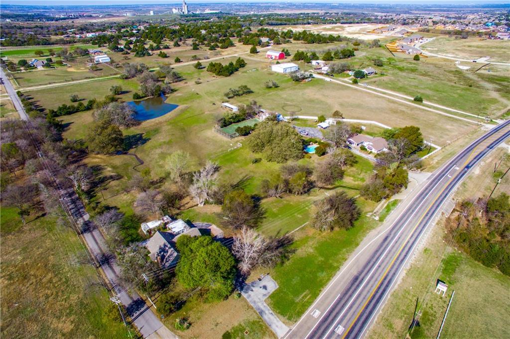 A developers dream!!! Over 13 acres of prime real estate, on the hard corner of Belmont and FM 663, directly across from Lawson Farms, and a mile from the new Kroger shopping center. Frontage on both FM 663 as well as Belmont. Beautiful treed acreage with seasonal lake. House shows 3862 square feet, with a swimming pool & 
guest house. There are tennis courts, a two-story party barn, 4 stall barn & 2 stall lean to. A 4800 square foot warehouse has 5 heated & cooled offices, a loading dock and  sits on almost 5 acres. Three separate legal descriptions comprise the total 13.395 acreage. If needed, listing agent will furnish the account number of each parcel. Value is in the land, but house & guest house can be shown with 24 hours notice.
