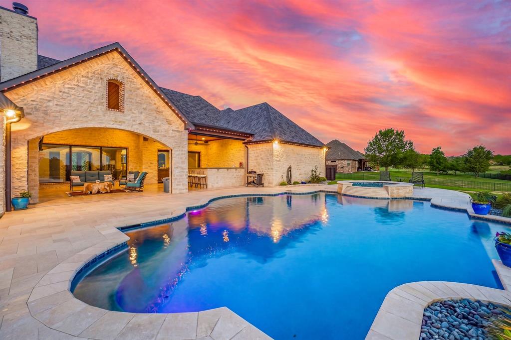 Luxury Custom Estate on 2.35 Acres - Canyon West - Brock ISD

Experience elevated living in this exceptional custom estate situated on 2.35 acres in the gated golf course community of Canyon West, located within the highly acclaimed Brock ISD. This thoughtfully designed single-story home offers the perfect blend of luxury, functionality, and refined craftsmanship.

From the moment you arrive, the striking curb appeal stands out with extensive stonework, manicured landscaping, and a commanding presence. Inside, the home features rich hardwood flooring, stone-accented walls, vaulted ceilings with exposed beams, and an open-concept layout designed for both everyday living and entertaining.

The chef’s kitchen is equipped with high-end appliances, including an imported Italian range, and is complemented by a built-in sound system that extends throughout the interior and outdoor living spaces. The spacious living area is anchored by a floor-to-ceiling stone fireplace and expansive windows that provide abundant natural light. A well-appointed wet bar seamlessly connects the main living areas, creating an ideal space for hosting.

The private primary suite offers a true retreat with beamed ceilings, a brick accent wall, and a spa-inspired bathroom featuring dual vanities, soaking tub, walk-in shower, and a custom closet. Additional features include a media room, fitness room, dedicated office with built-ins, oversized mudroom, and a fully equipped utility room with additional storage and space for a secondary refrigerator.

Step outside to a resort-style outdoor living area featuring a custom pool and spa with cascading waterfall, desert-inspired landscaping, and expansive seating areas designed for entertaining

A standout feature of the property is the 1+ acre custom pond with stonework, fountain, lighting, and fish-ready access, creating a peaceful and private setting. This property would make a great family home or an amazing business retreat property