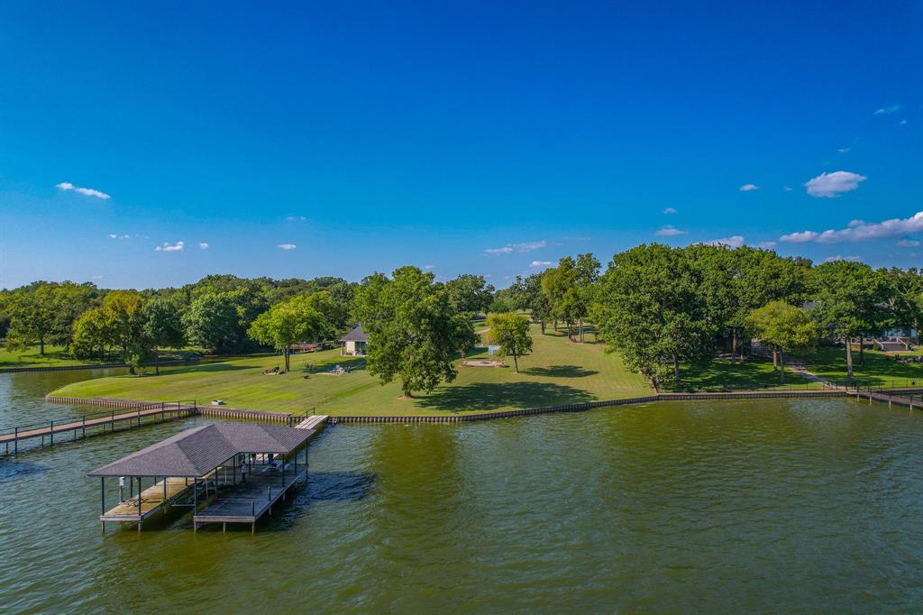 Welcome to the pinnacle of Texas lakeside luxury. This rare waterfront lot on Richland Chambers Reservoir offers a coveted blend of exclusivity, recreation, and natural beauty within the private, gated community of Francisco Bay. Perfectly situated on the northern shoreline, the property showcases sweeping views, direct water access, and a lifestyle defined by relaxation and adventure. Designed for year-round enjoyment, the property features a substantial metal retaining wall, a private boathouse with boat lift and secure storage, as well as a charming wooden pier with a built-in staircase leading directly into the cool, clear waters of Richland Chambers. From morning swims and paddleboarding to afternoons spent boating or casting a line for trophy bass, this retreat brings every recreational opportunity to your doorstep. Francisco Bay itself is a boutique, gated enclave known for its serene ambiance, lush greenery, and upscale amenities. Residents enjoy access to a sparkling community pool, pavilion, and shared gathering spaces that nurture a sense of community. Richland Chambers Reservoir, spanning more than 45,000 acres with over 330 miles of shoreline, is Texas' third-largest lake and a premier destination for boating, sailing, watersports, and world-class fishing. It’s a haven for outdoor enthusiasts and those seeking a peaceful escape from the city, without sacrificing convenience. Kerens lies just 7 miles away for daily essentials, Corsicana is 16 miles away for shopping, dining, and medical care, and the property is less than an hour from Dallas, Tyler, and Waco. This property is more than a homesite, it’s an invitation to a lifestyle where sunlit mornings on the dock, afternoons on the water, and evenings watching breathtaking lakefront sunsets become part of your everyday routine. Whether as a luxury weekend retreat or a full-time lakeside residence, this is an opportunity to create something truly special on the shores of Richland Chambers.
