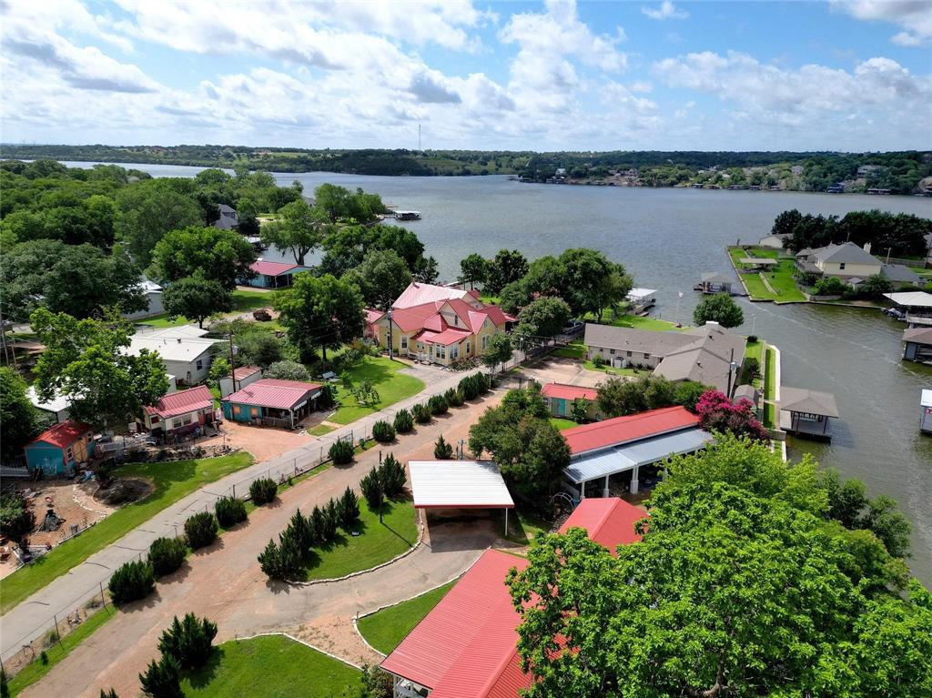 Amazing property on Lake Granbury. .532 acres of flat land backing to water canal with direct access to main body of lake. The property consists of three structures. The Refuge is a 2 bedroom, 2 bathroom building with huge front porch, open living area and peaceful back patio looking onto the canal. The Retreat is a 2 bedroom, 1 bathroom building with expansive back patio looking onto the canal. 3rd building is for storage. Ideal opportunity for a family retreat on Lake Granbury, primary residence, rental property (currently used as AirBnB) or develop the lot into your dream home. Central HVAC for both buildings, metal roofs, propane gas, septic and well water (not owned) are onsite for utilities. Peaceful area with easy access to everything Granbury offers. The owners have furnished both buildings meticulously over the years and it all Conveys to the buyer. All furniture, pictures, artwork, appliances convey. Move right in to your lake retreat. No City Taxes! If buyer does not want the buildings, owner will remove prior to closing.