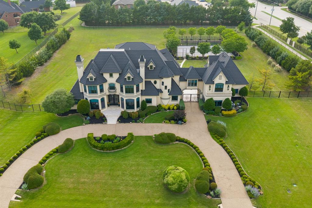 Extraordinary estate in Whispering Farms on 2.3 beautifully landscaped acres designed for luxurious everyday living and unforgettable entertaining! This exceptional property showcases a resort-style pool surrounded by expansive outdoor living spaces, creating a private retreat complete with a basketball sport court, batting cage, and underground 12-person storm shelter! Contemporary designer influences blend seamlessly with timeless architectural details, while premium finishes elevate every room.
A grand entry welcomes you with a winding staircase, immediate views of the sparkling pool, and a sophisticated dining room illuminated by a breathtaking statement chandelier. Just beyond, the formal living room offers its own fireplace and an elegant setting for intimate conversations and entertaining guests, while the expansive family room is framed by a wall of picture windows overlooking the backyard oasis and anchored by a stunning focal fireplace. Gourmet kitchen features built-in commercial refrigerator and freezer, 6 burner gas cooktop and grill, vented hood, double ovens, 2 dishwashers, prep sink, water filtration system, potfiller, walk-in pantry, and butler's pantry. The downstairs primary suite is a luxurious private sanctuary featuring a dramatic floor-to-ceiling fireplace, French doors opening directly to the pool patio, a spa-inspired bathroom with steam shower and therapeutic soaking tub, separate his-and-hers closets, and convenient washer dryer plumbing.
Designed with exceptional versatility, the home also features an upstairs mother-in-law suite complete with a built-in kitchen, a private guest suite, a fully equipped media room, game room with aquarium, private lounge with wet bar, an indoor fitness studio, and a designated office with its own fireplace. Every detail of this remarkable estate was curated to provide the ultimate blend of comfort, recreation, relaxation, and refined luxury, all within the highly sought-after Prosper ISD!