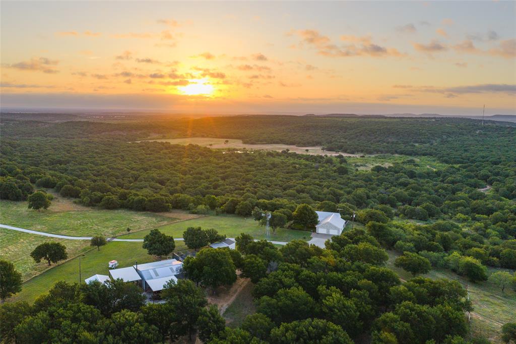 Rock Canyon Ranch is a remarkable 314.4± acre property offering an exceptional blend of ranching, recreation, hunting, and country living in the heart of North Texas. With approximately 125 feet of elevation change, rolling terrain, scenic views, and abundant wildlife, this ranch provides a rare opportunity to own a truly versatile property.

A gated entrance and long gravel driveway lead to a well-maintained, fully furnished 1,536± sq. ft. home featuring 3 bedrooms, 2 bathrooms, and a spacious 900± sq. ft. attached garage. Large windows and sliding doors fill the home with natural light, while the back deck showcases breathtaking views overlooking the ranch—perfect for enjoying sunrises, wildlife, and relaxing evenings outdoors.

Additional improvements include a 30x40 insulated shop, outdoor dog kennel, and a private water well producing approximately 35 GPM. The ranch has operated as a Longhorn cattle ranch for over 30 years and is fully fenced and cross-fenced, with working cattle pens and approximately 75± acres of productive pasture.

Water is a standout feature, with five stocked ponds offering excellent fishing for bass, bluegill, and catfish. Plum Creek runs through the center of the property, enhancing wildlife habitat and creating outstanding hunting opportunities for whitetail deer, turkey, hogs, dove, and other native species.

The ranch offers approximately 2,350 feet of Highway 16 frontage, attractive pipe and cable fencing, and convenient access while maintaining privacy and seclusion.

Located just 14± miles from Graham, 22± miles from Jacksboro, 47± miles from Wichita Falls, and 83± miles from Fort Worth, Rock Canyon Ranch is an outstanding opportunity to own a turnkey Texas ranch with agricultural, recreational, and residential appeal.

Existing survey available. Property is Ag Exempt. Seller does not own mineral rights; none will convey.

All showings are by appointment only.