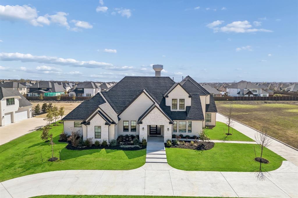 Discover the perfect balance of serene country living and urban convenience in this stunning transitional modern estate. Nestled on a sprawling 1.14-acre lot in the exclusive KingsBridge community of Parker, TX, this 2023 masterpiece by CHR Custom Homes offers over 5200 square feet of sophisticated design tailored for luxury and tranquility.

The journey begins at the massive custom entry door, leading into a unique foyer that opens to a light-filled living room with soaring ceilings and a modern gas fireplace. The open-concept layout seamlessly connects the private office and formal dining room to a chef’s dream kitchen. Equipped with the Monogram Kitchen Series, a wine fridge, and an expansive walk-in pantry that spans the entire length of the kitchen, this space is designed for both high-end entertaining and daily comfort.

This home features five spacious bedrooms, each with its own ensuite bathroom, plus two additional half baths. The primary suite serves as a first-floor sanctuary, featuring a spa-inspired bathroom with double shower heads and dual custom closets. A separate first-floor guest suite is ideal for visitors, accompanied by a versatile bonus room. For entertainment, the second level hosts three ensuite bedrooms and a dedicated media room wired for professional-grade surround sound and projection.

Exceptional amenities include a massive four-car garage pre-wired for electric vehicle charging, plus additional carport spaces. The outdoor living experience is elevated by a double back patio wired for media and a gas connection, perfect for a custom outdoor kitchen.