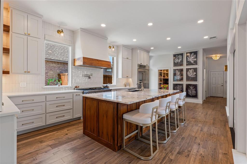 Beautifully renovated and move-in ready, this stunning 5-bedroom home offers the perfect blend of luxury, comfort, and everyday livability in the highly sought-after Stonebridge Ranch community, with access to top-rated schools and resort-style amenities. Priced to sell, this exceptional home features 3 full baths and 2 half baths, along with a flexible floor plan designed for modern living. The primary suite, private office, and guest bedroom are all conveniently located on the first floor, creating the ideal setup for families and guests alike.

At the heart of the home is a truly exceptional designer kitchen showcasing elegant Oyster White marble countertops, a 48-inch range with statement hood vent, built-in refrigerator, warming drawer, and microwave drawer. Thoughtfully designed custom cabinetry includes a built-in charging drawer, dedicated pots and pans drawers, sheet pan storage, coffee station, pull-out trash cans, and specialized spice and utensil pull-outs—perfectly blending high-end design with everyday functionality. An oversized walk-in pantry completes this incredible space, making it ideal for both daily living and entertaining.

Multiple living areas invite you to relax and connect, highlighted by two newly designed fireplace facades—limestone in the family room and porcelain tile in the front living room—plus a third fireplace in the serene primary suite. Custom family room built-ins with rich walnut shelving and undermount lighting add warmth and sophistication throughout the home.

Step outside to your own private backyard retreat featuring a luxurious newly updated pool and spa with travertine coping and a fully retiled finish—perfect for summer days, family fun, and evening entertaining. Additional highlights include an oversized 3-car garage.
Located in one of the most desirable sections of Stonebridge Ranch, this beautifully updated home combines timeless style, thoughtful upgrades, and an unbeatable lifestyle opportunity.
