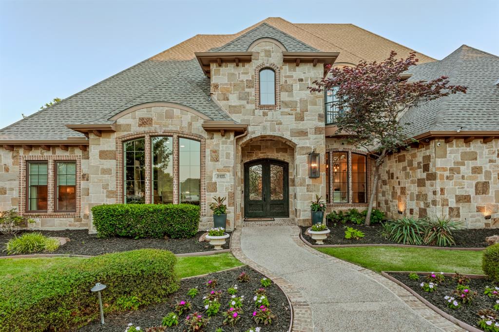 Welcome to 5405 Lake Windermere Drive ,a Lewis and Early exceptional estate nestled within the coveted, enclave of Bella Lago in Flower Mound, Texas. This stunning 5,861 square foot masterpiece offers the perfect blend of refined luxury and relaxed elegance, set on a sprawling one-acre lot enveloped by mature trees that provide the ultimate in privacy and natural beauty.
From the moment you arrive, soaring vaulted ceilings and an open, light-filled floor plan set the tone for the seamless indoor-outdoor living experience this home delivers. Designed for the discerning entertainer, the thoughtfully designed layout features a spectacular bar area, dedicated media room, and expansive game room — ensuring every gathering, from intimate evenings to grand celebrations, is effortlessly accommodated.
The heart of the home flows naturally to the outdoors through generous transitions that blur the line between inside and out. Step onto the oversized covered patio — a true outdoor living room — complete with a cozy fireplace, fully equipped outdoor kitchen, and privacy screens that create a serene, resort-like retreat right in your backyard. Unwind or entertain poolside with the stunning pool and spa as your backdrop, all framed by the lush, tree-lined privacy of your one-acre sanctuary.
With 4 generously sized bedrooms, 5 beautifully appointed bathrooms, and premium finishes throughout, every detail of this home speaks to quality and craftsmanship. Bella Lago is one of Flower Mound's most exclusive communities, offering an unmatched lifestyle just minutes from top-rated schools, premier dining, shopping, and easy access to DFW Airport.
Rare in scale, unmatched in setting — 5405 Lake Windermere is not just a home, it's a lifestyle.