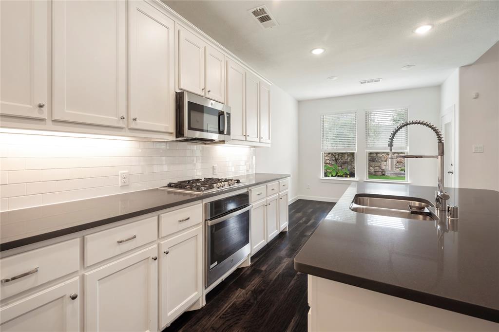 Experience elevated living in this stunning former Highland Homes model home, perfectly situated on a professionally landscaped desirable corner lot. Designed with both style and functionality in mind, this home features a rare 2.5 car garage with epoxy floors, patio door access to the backyard, and decked attic storage for exceptional organization and convenience. Inside, you’ll find a thoughtfully designed floor plan with two bedrooms upstairs along with a spacious game room and versatile loft area—ideal for entertaining, work, or relaxation. The main level offers the perfect setup for multi-generational living or guests with an additional private guest suite alongside the luxurious primary retreat. Recent updates include brand-new carpet, microwave, and dishwasher, while major systems have been well maintained, including a 5 year-old water heater. The home is also plumbed for gas, offering added flexibility for future upgrades. Additional features include an upstairs AC mechanical room conveniently tucked into a storage closet. Harvest Community boasts pools, nature trails, parks, organized community activities, and a town green. 1700 Homestead Way is a beautifully maintained former model home that combines upgraded finishes, functional living spaces, and a prime location—making it truly move-in ready.