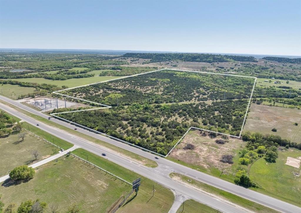 Rarely does a property of this size and strategic location become available—106+ acres situated just outside the city
limits with approximately 900+ feet of highway frontage in a rapidly growing area. This unique tract offers a perfect
blend of accessibility, privacy, and development potential. Heavily wooded and rich with natural beauty, the land is
teeming with wildlife and features two seasonal creeks, a hand-dug well, a rustic shed, and remnants of an old
homestead that add character and charm. The perimeter is fully fenced, making it ideal for a variety of uses—from
residential development to recreational retreats or commercial ventures. Located only 5 miles from the historic
Granbury Square and the Granbury Regional Airport—now upgraded with a new 5,200-foot runway—this property offers
exceptional convenience. It’s also just an hour from DFW International Airport, combining rural seclusion with
outstanding regional and international accessibility. Whether you're looking for a prime development site, a long-term
investment, or a scenic escape with strong growth potential, this versatile tract presents endless possibilities. With high
visibility, easy access, and proximity to key amenities, this is your chance to own a rare piece of land in a highly
desirable location. Don't miss this exceptional opportunity—schedule your showing today.