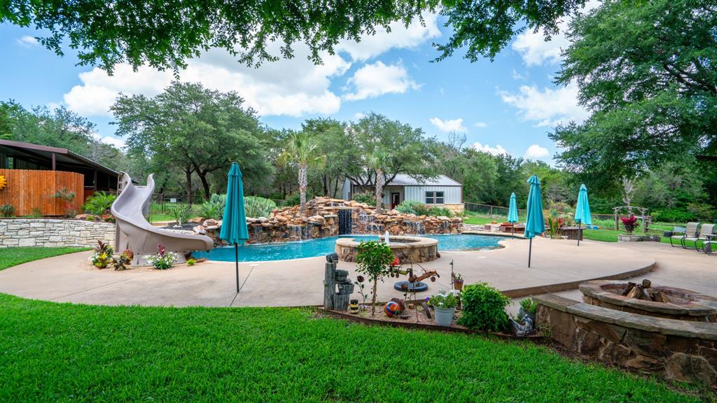 One of a kind rural property centrally located between Granbury, Tolar and Glen Rose that makes staying at home feel like a vacation! 3 bedroom, 2.5 bath with study or 4th bedroom and gameroom in the main house. Two living areas equipped with RBH speakers. This one story stone house is secluded on over 8 acres with pond, resort like swimming pool, guest house, horse stalls and shop as well as an unbelievable playground including a swing set and merry-go-round  Newer appliances, hot water heaters and HVACs. The patio area includes a full outdoor kitchen and dining area with a grill, sink, everything needed for outdoor entertainment and a large custom made red cedar table with seating for a dozen or more. Poolhouse currently is set up as a gamehouse with shuffleboard, poker table, pool table, and 10 ft projection screen tv. The 1100 sq ft gamehouse (poolhouse) with a full bath and separate HVAC and septic system could easily be converted to living quarters for extended family. Property is on a well. Well house has additional storage.  The property is truly an entertainment paradise.