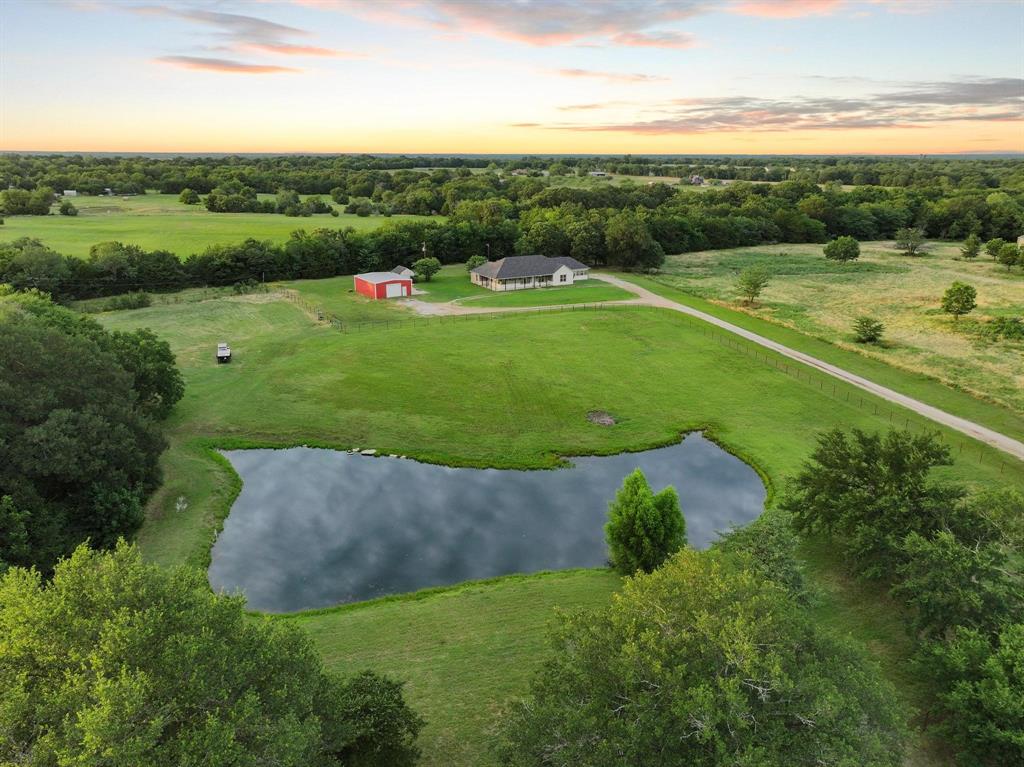 Welcome to 7106 County Road 4729 in Commerce, TX. Nestled on 10.58 beautiful acres this spacious 3,070-square-foot home offers four bedrooms and two bathrooms with an open-concept floor plan designed for both everyday living and entertaining. The large living area flows seamlessly into the eat-in kitchen, creating a warm and inviting gathering space. A cozy sitting area and sunroom provide additional space to relax. 
One of the home's standout features is its flexible layout, offering excellent potential for a multigenerational living arrangement or in-law suite. A side exterior entrance provides added privacy and convenience for guests, extended family, or a home office setup.
The property features a pond, mature trees, and plenty of open space, cross fencing for animals, gardening, or simply enjoying the beauty of country living.

A metal building provides valuable storage space for equipment, vehicles, hobbies, or workshop projects. With beautiful acreage, a private setting, covered outdoor living areas, and a versatile floor plan, this property offers the best of country living while remaining conveniently located near Commerce.
This unique property is ready to welcome you home.