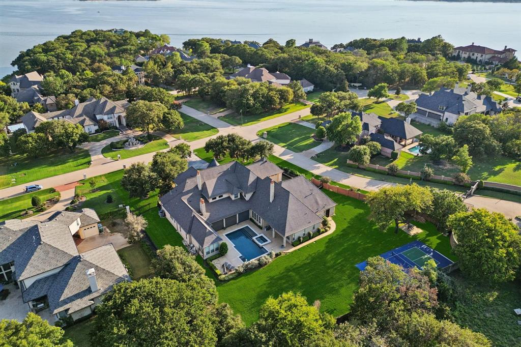 Nestled on a sprawling 1.229-acre lot within the prestigious gated enclave of Point Noble on Grapevine Lake, this breathtaking estate has been masterfully renovated to blend timeless elegance with modern luxury. A grand foyer with a sweeping staircase sets a majestic tone upon entry, offering an unforgettable first impression. At the heart of the home lies a chef’s kitchen of unrivaled quality, where beamed ceilings soar above professional-grade Wolf appliances, a vast island, and a discreet butler’s pantry—designed for both grand entertaining and everyday indulgence. Throughout the home, brand-new flooring enhances each meticulously reimagined space, while a new high-efficiency HVAC system with an advanced EV air conditioning upgrade ensures comfort year-round. The fully updated garages feature custom cabinetry systems and pristine epoxy flooring, ideal for car enthusiasts and collectors alike. Designed for luxurious living, the estate boasts a wealth of exceptional amenities, including dual game rooms, a stately study, a glass-enclosed wine room for showcasing your finest vintages, a state-of-the-art home theater, and a private gym. Car enthusiasts will appreciate the five-car garage and gated motor court. Outdoors, a resort-style pool and spa shimmer under the Texas sun, while a private pickleball court offers the perfect balance of recreation and leisure. Set against a backdrop of serene natural beauty, this estate embodies the essence of a private resort, where sophistication meets tranquility in one of the most coveted locations on Grapevine Lake.