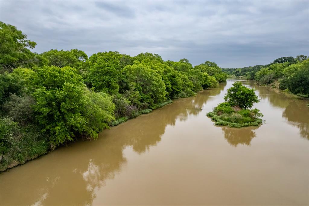 Experience the rare combination of privacy, natural beauty, and recreational opportunity with this exceptional riverfront ranch in South Coleman County. Tucked away in a secluded setting, this property boasts over ¾ mile of pristine Colorado River frontage, just east of the historic Waldrip Bridge, offering a peaceful retreat with rich Texas heritage.
Adding to its uniqueness, there are more than 1.5 miles of Bull Creek winding through the ranch before converging with the Colorado River, creating diverse terrain, scenic water features, and prime wildlife habitat. This is a true sportsman’s paradise, with outstanding hunting for whitetail deer, turkey, waterfowl, and a variety of exotics including axis deer, aoudad sheep, and blackbuck.
The land has unique natural features for both recreation and long-term value, including 40 acre-feet of irrigation water rights, with mineral rights conveying to the buyer. Whether you’re kayaking along the river, exploring the creek beds, or enjoying a quiet evening under the stars, the property offers endless outdoor enjoyment.
Improvements include a small hunting cabin served by county electricity and co-op water along with a water well and internet available on-site—providing modern convenience in a rugged, natural setting. The ranch is also rich in history, with numerous arrowheads and artifacts discovered throughout the property.
The landscape is dotted with mature oaks, elms, and mesquite, while seasonal blue bonnets blanket the ground with vibrant color, enhancing the already breathtaking scenery.
This is a rare opportunity to own a highly desirable stretch of the Colorado River with exceptional recreational appeal, natural beauty, and investment potential.
