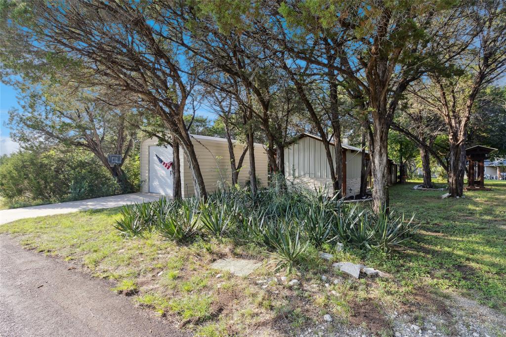 Prime land situated close to beautiful Lake Granbury includes a 256 square foot one bedroom cabin and a 30x18 outbuilding. Nestled on .688 acres this serene property includes 6 different lots all side by side, and is ready to be your recreational getaway or place to build your future home. Quiet, tree filled lot with septic, water and completed road is just minutes from a private boat ramp and park for homeowners only. Three minutes from Home Depot and dining, five minutes to a hospital and ten minutes from the downtown square. The cabin has one bedroom (14x10), kitchen (21x11) that includes microwave, outdoor grill and wine cooler and a living area (22x11) that features a hot tub and a fireplace. The oversized outbuilding has a concrete floor, water, electricity and pull through capability. No HOA! Don't miss this opportunity to secure your slice of tranquility!